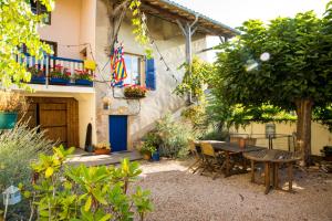 a patio with a table and chairs in front of a house at Les Portails Bleus in Azé