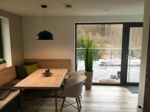 una sala da pranzo con tavolo e sedie in legno di Ferienhaus "Haus Sommerstieg" a Waltershausen