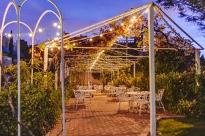 Forest Villas Hotel في بريسكوت: قزاز بطاولات بيضاء واضاءة في حديقة