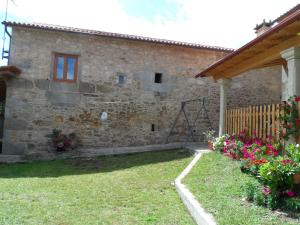 an external view of a stone house with flowers at Casa Barqueiro in Outes