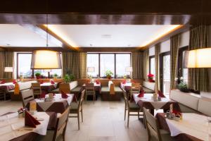 un ristorante con tavoli, sedie e finestre di Belvedere a Semmering