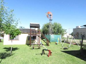 un patio con un parque infantil con un molino de viento en Complejo Molino de las Termas, en Gualeguaychú