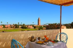 einen Tisch mit Speisen und Getränken auf dem Balkon in der Unterkunft Riad Sidi Mimoune & Spa in Marrakesch