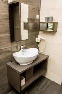 a bathroom with a sink and a mirror at Erzsébet Hotel in Csongrád +37 photos
