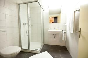 a bathroom with a shower and a toilet and a sink at Hotel Goldener Schlüssel in Altdorf