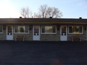 a brick house with two benches in front of it at Lion Motel in Long Sault