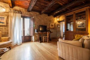 a living room with a couch and a television at Casa del Mago in Castelmezzano