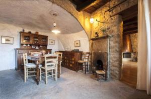 a dining room with a table and a fireplace at Casa del Mago in Castelmezzano