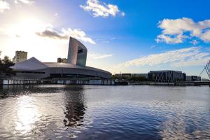 a building with a pool of water in front of it at Royal Oak Home in Wythenshawe