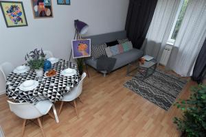 a living room with a table and a couch at Hello Warsaw! Calm Artistic City Center Apartment in Warsaw