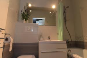a bathroom with a sink and a toilet and a mirror at Hello Warsaw! Calm Artistic City Center Apartment in Warsaw