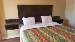 a bedroom with a large bed with a large headboard at ACE Motel in Pasadena