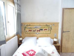 a bedroom with two beds and a painting on the wall at Apart'hotel & Spa "La Destière" in La Giettaz