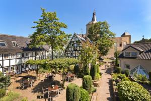 ベルギッシュ・グラートバッハにあるMalerwinkel Hotelの木々の茂る中庭