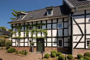 ベルギッシュ・グラートバッハにあるMalerwinkel Hotelの緑の扉のある古い白黒の家 +60枚の写真