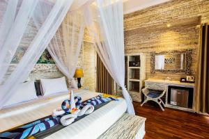a bedroom with a bed and a desk in a room at The Palm Grove Villas - CHSE Certified in Nusa Lembongan