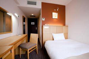 a bedroom with a bed and a desk and a chair at Hotel St Palace Kurayoshi in Kurayoshi