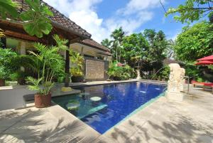 a swimming pool in the backyard of a house at Yulia Beach Inn Kuta in Kuta