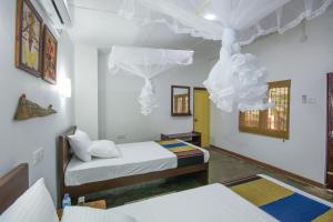a bedroom with two beds and a white ceiling at Udawatta Kele (UK) Forest Lodge in Kandy