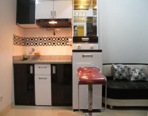 eine kleine Küche mit einer Theke und einem Stuhl in der Unterkunft Apartment Green Pramuka ~ OCR in Jakarta