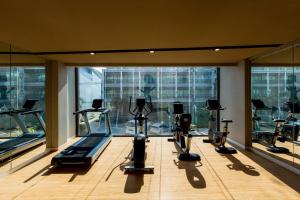 a gym with several tread machines in a room with windows at GLOW Ao Nang Krabi in Ao Nang Beach