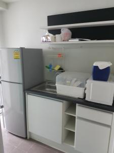 a kitchen with a white refrigerator and a counter at The Idol Bangsaen 206 in Bangsaen