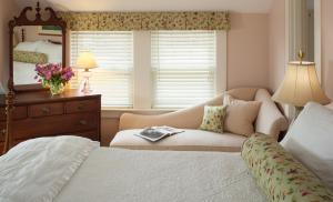 a bedroom with a bed and a chair and a mirror at Sugar Hill Inn in Sugar Hill