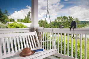 a hat sitting on a swing on a porch at Sugar Hill Inn in Sugar Hill