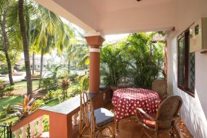 un patio con mesa y sillas en un porche en Villa La Casita en Cavelossim