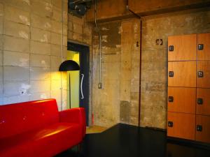 a red couch in a room with a brick wall at Midnight Rockers in Kanazawa +35 photos