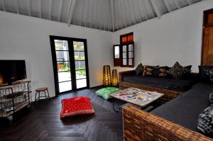 a living room with a couch and a table at Holiday beautiful Villa 4 Bedroom Garden View Canggu in Canggu