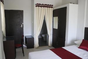 JaliapāraにあるSunset Serenityのベッドルーム1室(ベッド1台付)、窓、トイレが備わります。