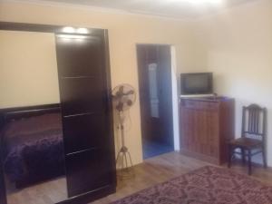 a bedroom with a bed and a dresser and a television at Guest House Gikacha in Tbilisi City