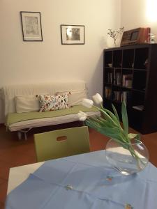 een woonkamer met een bank en een vaas met bloemen bij Casa Belfiore Da Andrea in Ferrara