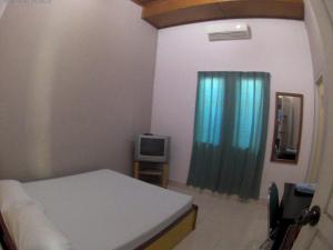 A bed or beds in a room at Wisma Maharani