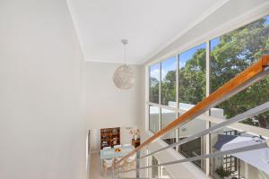 una scala bianca in una casa con una grande finestra di The Courtyards on Hill St a Sunshine Beach