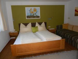 Bett in einem Zimmer mit grüner Wand in der Unterkunft Haus Lutz in Prutz
