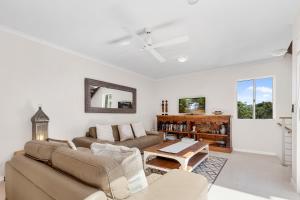 een woonkamer met een bank en een tafel bij The Courtyards on Hill St in Sunshine Beach