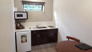 a small kitchen with a sink and a table at Rose City Motel in Palmerston North