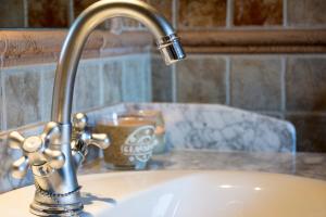 a bathroom sink with a faucet and a cup on a counter at Casas Bajas Alojamiento Rural in Casas Bajas