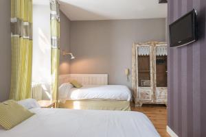アルジュレス・ガゾストにあるVilla Bon Reposのベッド2台とテレビが備わるホテルルームです。