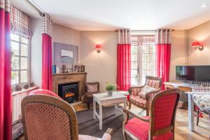 a living room with a fireplace and red curtains at Villa Bon Repos in Argelès-Gazost