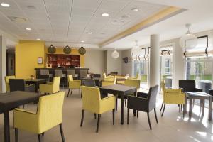une salle à manger avec des tables et des chaises jaunes dans l'établissement Domitys La Clef des Champs, à Poitiers