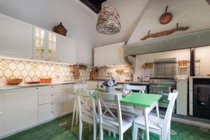 una cucina con tavolo verde e armadietti bianchi di Enchanting Medici's Mansion 7 min from Florence a Fiesole