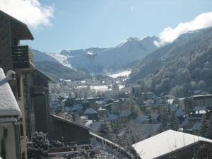 a view of a town with snow covered mountains at chez Angèle in Le Mont-Dore