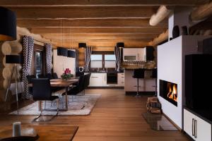 a living room with a dining room table and a fireplace at Chalet - Lomnica in Tatranská Lomnica