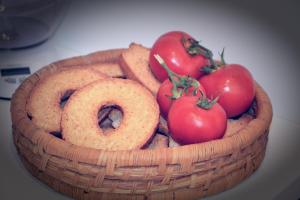 a basket of tomatoes and bagels on a table at Casa Gioia in Taranto
