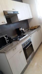 cocina con armarios blancos y fogones en Appartement Agadir, en Agadir