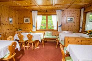 a dining room with tables and chairs in a room at Gästehaus Tannegg in Mittelberg