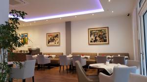a dining room with white tables and chairs at City Hotel Niederrad in Frankfurt